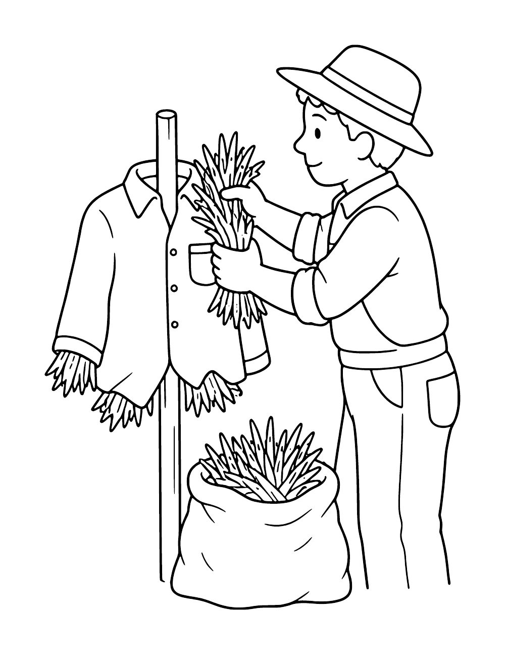 Person in a brimmed hat adding straw to a scarecrow shirt on a wooden post, beside an open sack of straw.